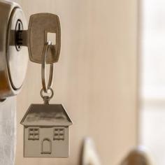 Une clé avec un pendentif représentant une maison, symbolisant l'accès à un foyer.
