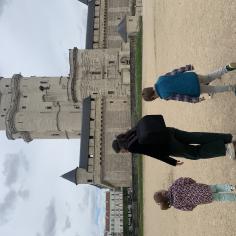 Photo d'un adulte et deux enfants devant le donjon du Château