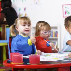 enfants qui jouent sur une table et colorient