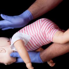 photo d'une personne pratiquant des gestes qui sauvent sur un mannequin bébé 