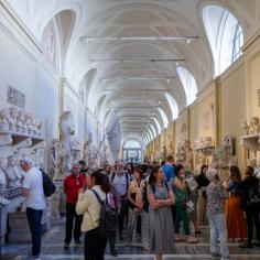 Touristes regardant des sculptures antiques de Romains dans le couloir du musée Chiaramonti à la Cité du Vatican - Image Libre de Droit