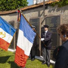 Des hommes soldat tiennent des drapeaux lors d'une cérémonie