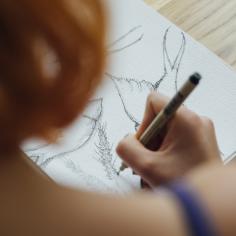 On voit de dos une personne qui dessine