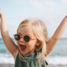 Drôle d’enfant fille jouant en plein air surpris enfant émotionnel dans des lunettes de soleil 3 ans bébé levé mains vacances en famille