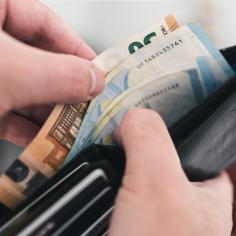 Vue rapprochée des mains qui sortent de l’argent d’un portefeuille