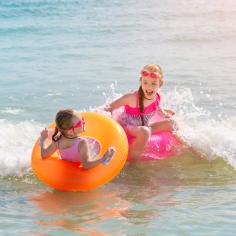 Deux petites sœurs jouent et s’amusent dans l’eau de mer sur la plage