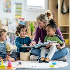 Enseignant lisant un livre à de jeunes enfants dans une salle de jeux