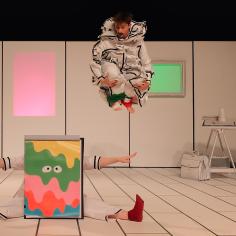 Deux danseurs déguisés sur scène, l'un saute et l'autre est assis