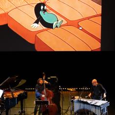 Des musiciens sur scène avec une projection de dessin animé