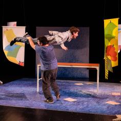 Un homme en tient un autre sur son épaule sur une scène de spectacle