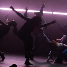 Un groupe de danseurs dans une lumière tamisée 