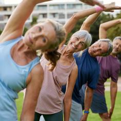 Groupe mature multiethnique de personnes pratiquant des étirements au parc