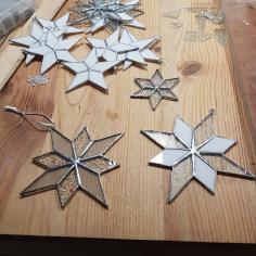 Des vitraux en forme d'étoile posées sur une table en vous 