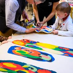 Des personnes regardes des affiches colorées posées sur une table