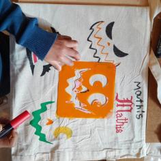 Des enfants colorient un sac d'halloween
