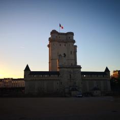 une photo du château de vincennes au moment du couché du soleil