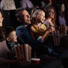 Famille joyeuse regardant un film drôle au théâtre