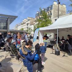 Un groupe de musique joue devant une foule rassemblée sur une place de Vincennes.