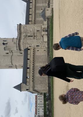 Photo d'un adulte et deux enfants devant le donjon du Château