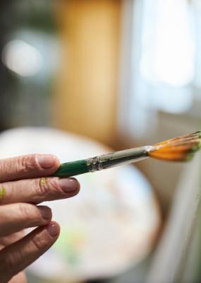 photo d''un peintre tenant un pinceau couleur verte