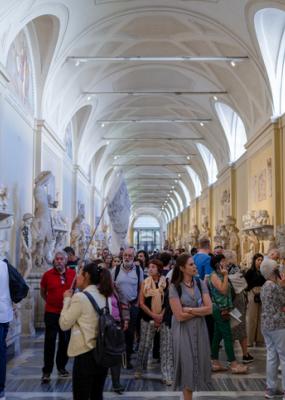 Touristes regardant des sculptures antiques de Romains dans le couloir du musée Chiaramonti à la Cité du Vatican - Image Libre de Droit
