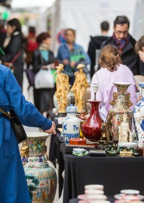 On y voit deux personnes devant un stand avec des antiquités