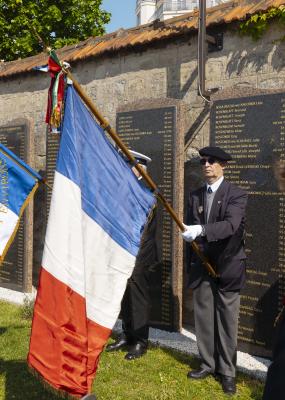 Des hommes soldat tiennent des drapeaux lors d'une cérémonie