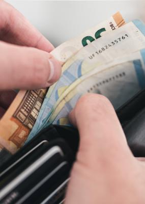 Vue rapprochée des mains qui sortent de l’argent d’un portefeuille