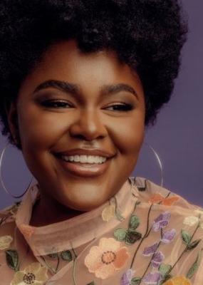 une femme souriante porte de grandes créoles 