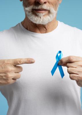 Un homme âgé pointant du doigt un ruban bleu pour soutenir la sensibilisation au cancer du côlon
