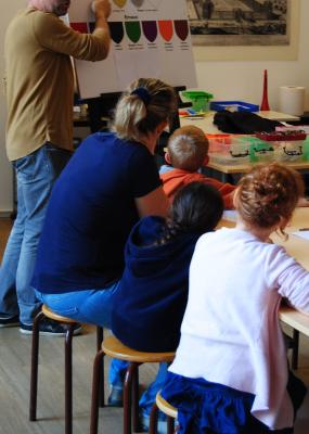 Des personnes sont installées sur une table et écoutent un orateur