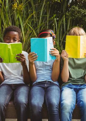 Enfants lisent des livres dans le parc