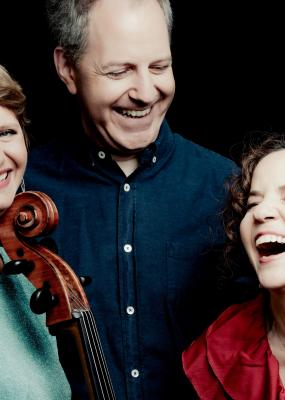 Un groupe de 3 artistes rient ensemble