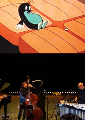 Des musiciens sur scène avec une projection de dessin animé