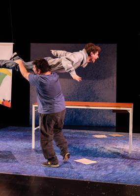 Un homme en tient un autre sur son épaule sur une scène de spectacle