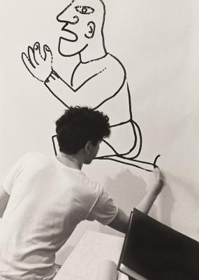 un jeune homme dessine sur un mur