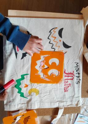 Des enfants colorient un sac d'halloween
