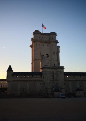 une photo du château de vincennes au moment du couché du soleil