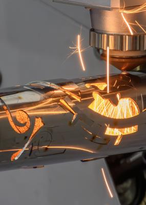 Scène rapprochée de la machine de découpe laser à fibre a coupé le tube en acier inoxydable et la lumière étincelante.