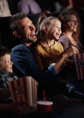Famille joyeuse regardant un film drôle au théâtre