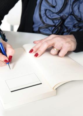 Une femme dédicace un livre