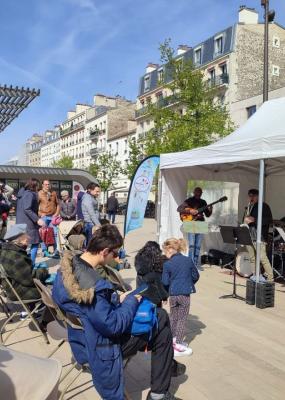 Un groupe de musique joue devant une foule rassemblée sur une place de Vincennes.