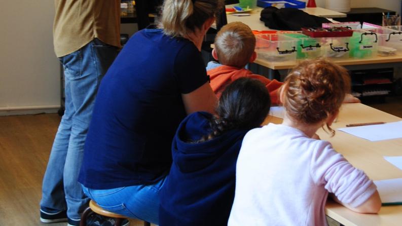photo d'un groupe de personnes dans une classe en train d'écouter le professeur