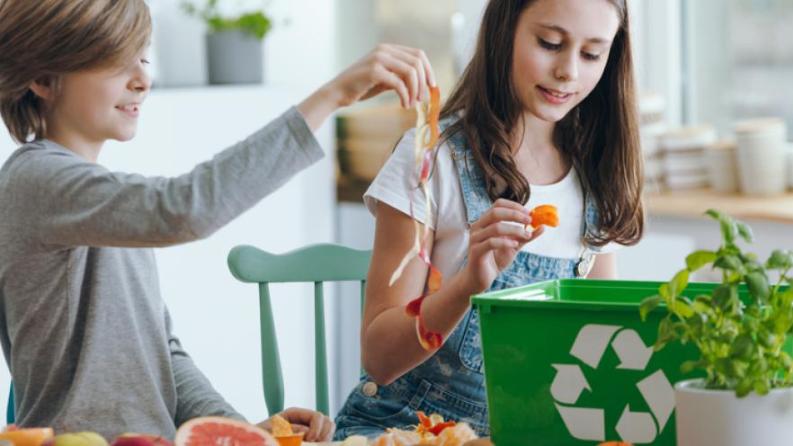 Photo de deux enfants en train de faire du tri sélectif des déchets