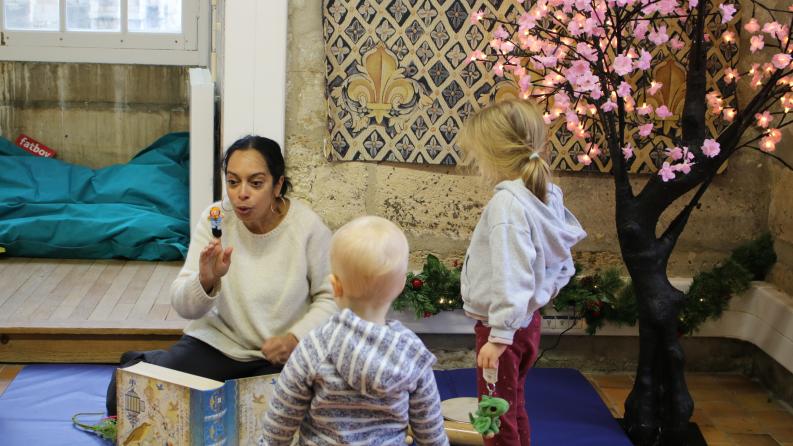 photo avec une animatrice qui compte des histoires à des enfants