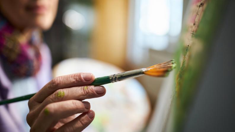 photo d''un peintre tenant un pinceau couleur verte