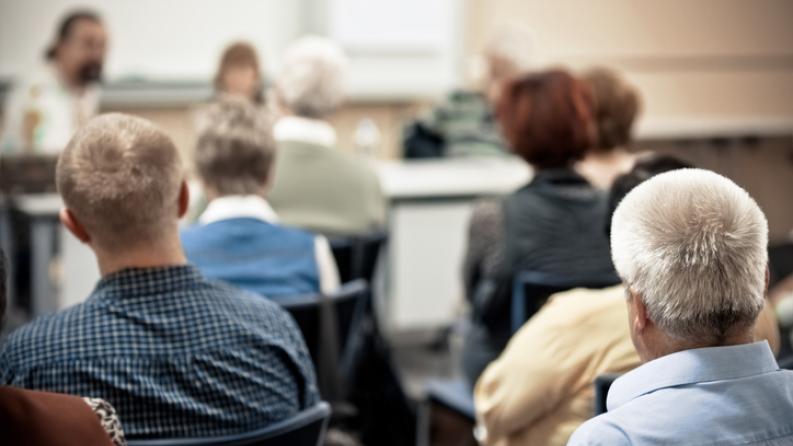 photo de seniors de dos à une conférence