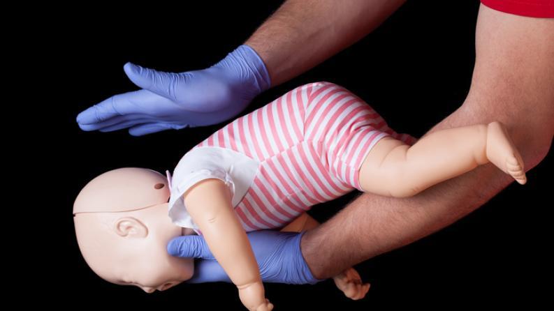 photo d'une personne pratiquant des gestes qui sauvent sur un mannequin bébé 