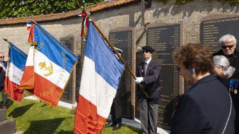 Des hommes soldat tiennent des drapeaux lors d'une cérémonie