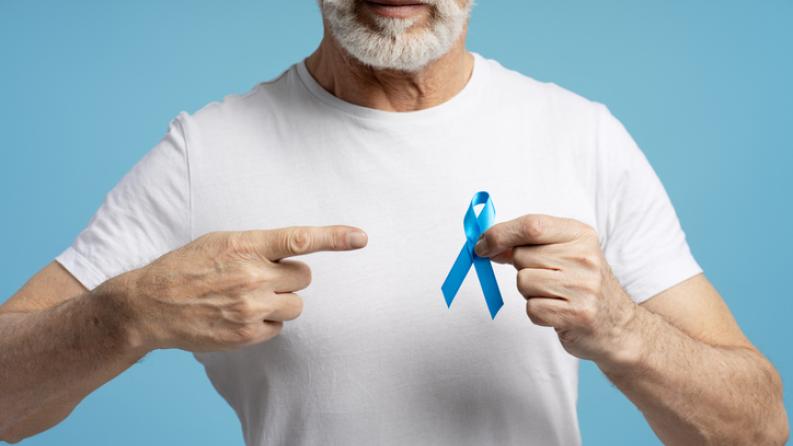 Un homme âgé pointant du doigt un ruban bleu pour soutenir la sensibilisation au cancer du côlon